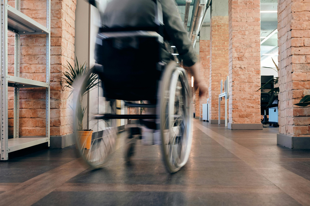Close-up of a wheelchair's wheels on a smooth indoor surface, symbolising mobility and accessibility support.